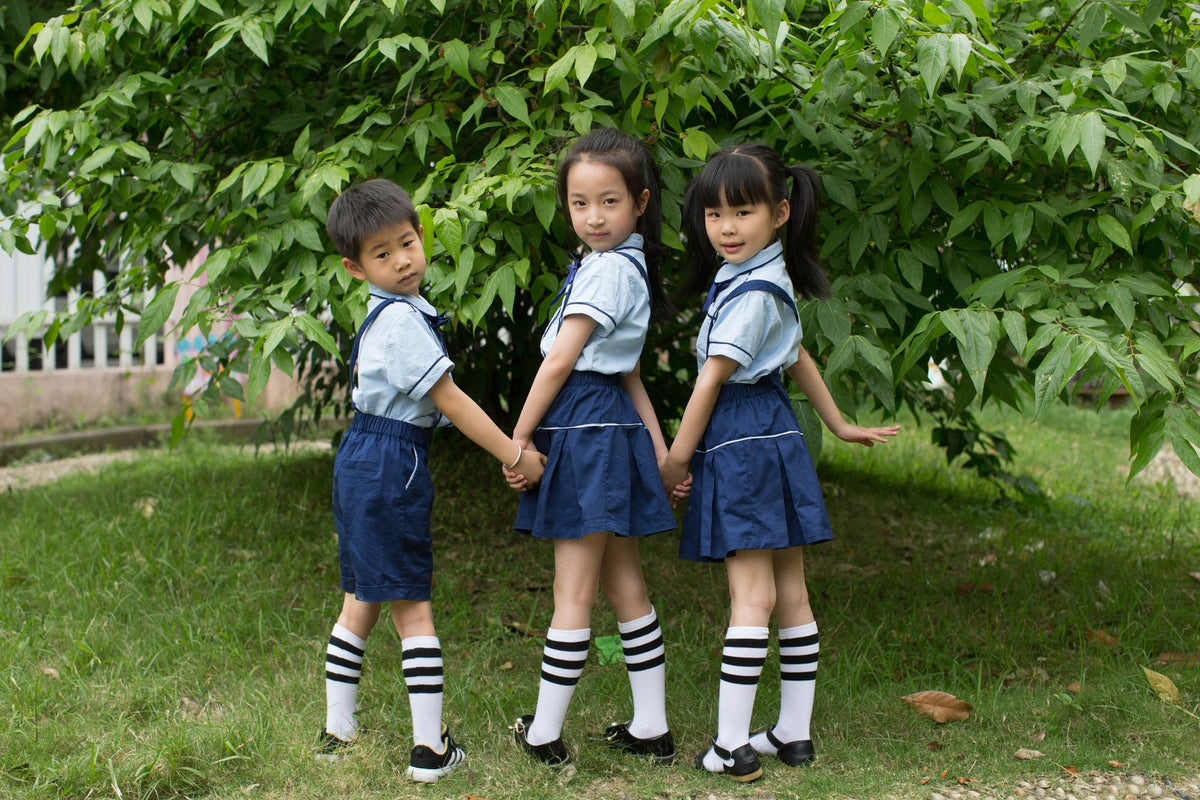 Niñas y niño con uniforme escolar y calcetas largas